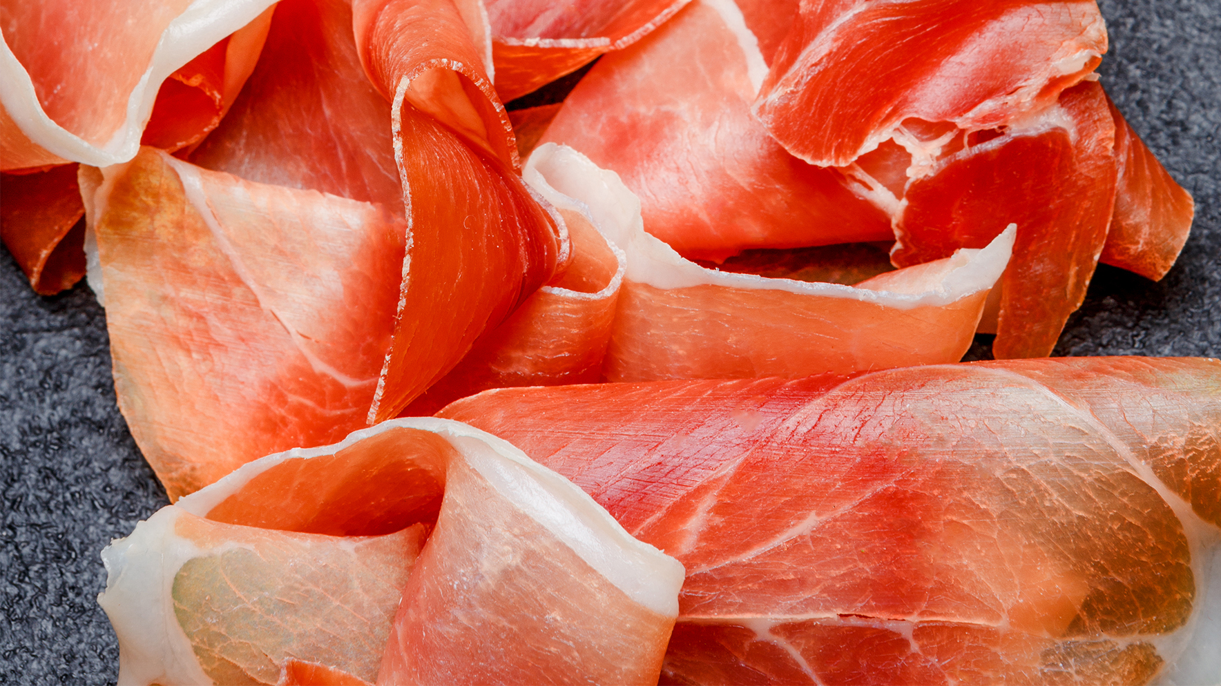 Perché talvolta al taglio di un salume stagionato si vedono fette con colorazioni iridescenti?